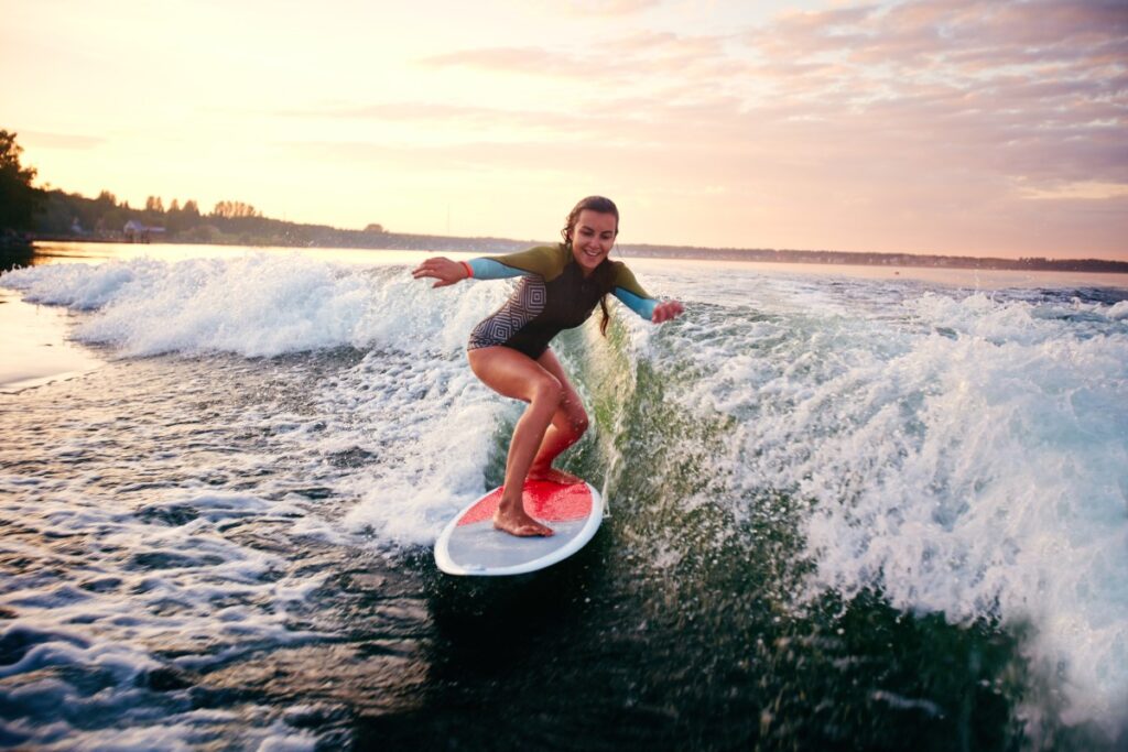 Beginners enjoying surf lessons in Tamarindo, learning to balance on surfboards with professional guidance and calm ocean waves.